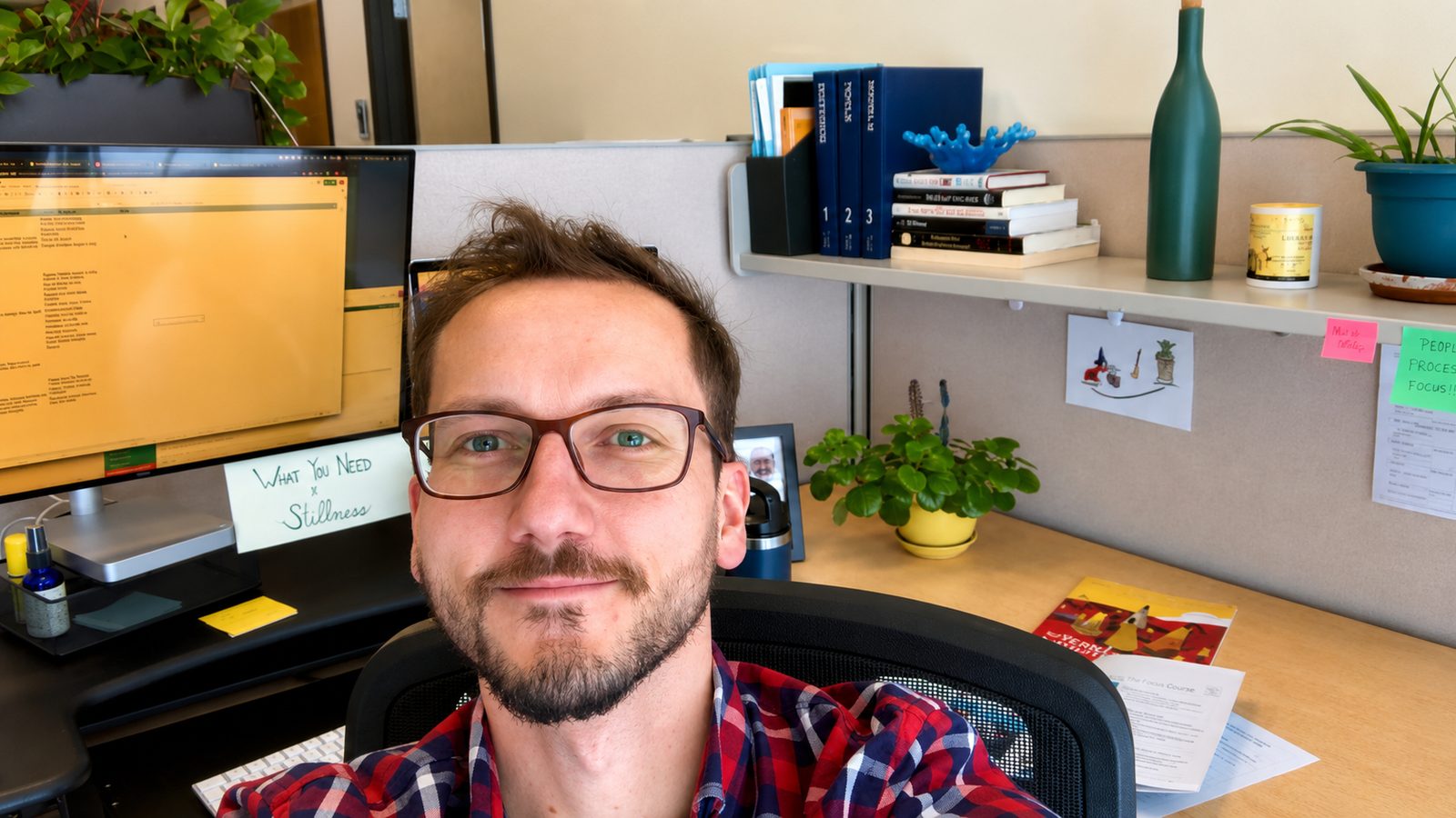 Roberto at his desk with a sticky note that reads 'What You Need is Stillness'